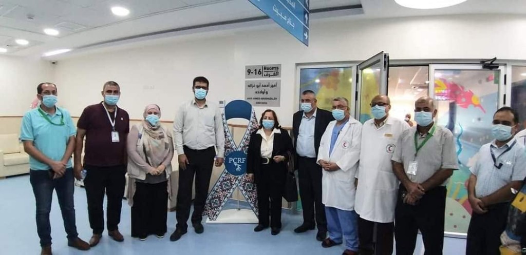 د. أبو ندى مع الفريق بجانب شريط PCRF في المستشفى