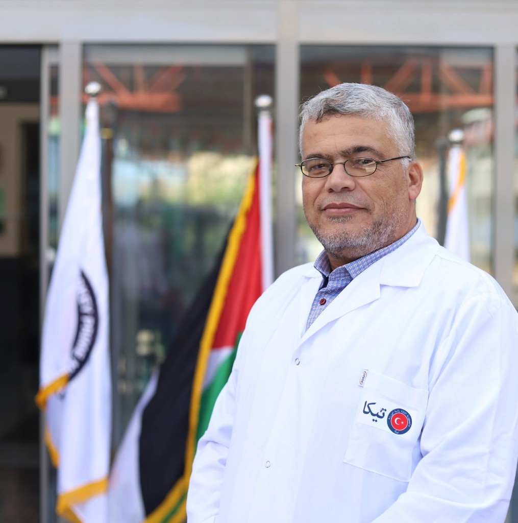 د. أبو ندى بمعطف أبيض عليه شعار وكالة التعاون التركية تيكا